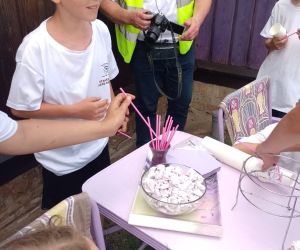 Grupa uczniów próbuje lawendowe przysmaki: bezy i lemoniadę