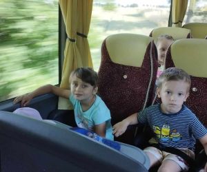 Przedszkolaki siedzą na fotelach w autokarze