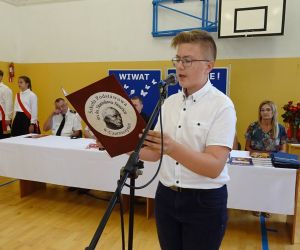 Uczeń klasy siódmej stoi przy mikrofonie i otwiera uroczystość