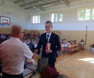 Ósmoklasista przyjmuje od Dyrektora świadectwo ukończenia szkoły