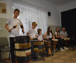 Na zdjęciu widoczna jest grupa muzyków grających na bębnach.