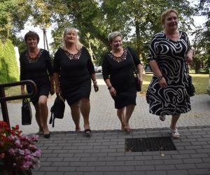 Na zdjęciu widoczne są cztery kobiety wchodzące do budynku.