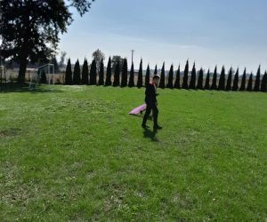 Uczeń zbiera śmieci do worka na boisku