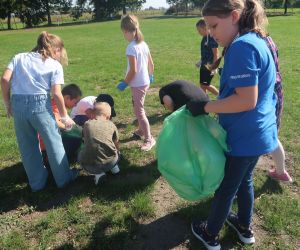 Dzieci zbierają śmieci na boisku szkolnym