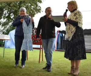 Zdjęcie przedstawia trzy osoby licytujące przedmioty.