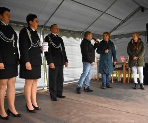 Zdjęcie przedstawia osoby stojące na scenie.