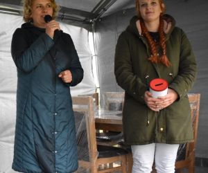 Zdjęcie przedstawia osoby stojące na scenie.