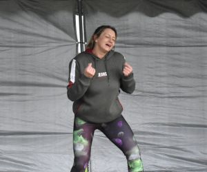 Zdjęcie przedstawia osobę prezentująca zumbę na scenie. 