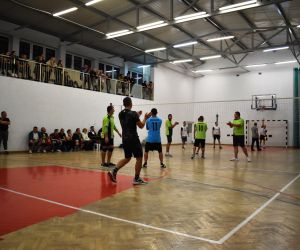 Zdjęcie przedstawia drużyny rozgrywające mecz piłki siatkowej, który odbywa się na hali sportowej.