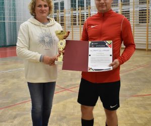 Na zdjęciu znajdują się dwie osoby. Jest to zdjęcie przedstawiające przekazanie pucharu kapitanowi drużyny, która znalazła się w finale.