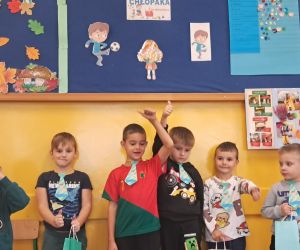 Chłopcy prezentują się w krawatach.