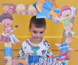 Chłopiec trzyma kolorową ramkę.