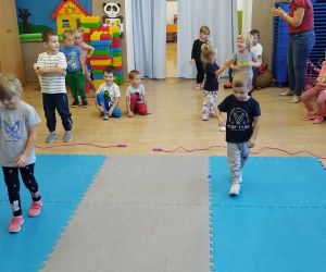 Chłopiec i dziewczynka niosą jajka na łyżkach na wyścigi