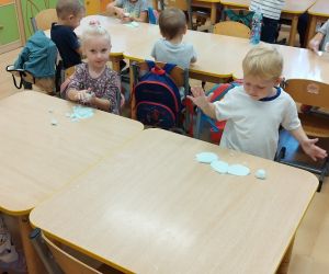 Przedszkolaki przy stolikach lepią z masy plastycznej