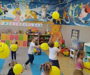 Przedszkolaki bawią się żółtymi balonikami