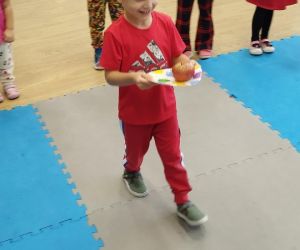 Chłopiec niesie jabłko na talerzyku