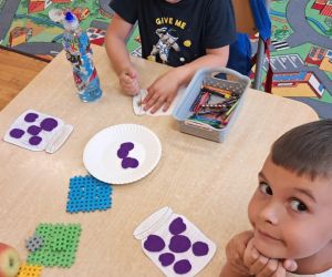 Dzieci wyklejają plasteliną owoce.