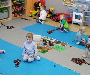 Przedszkolaki układają drzewa z kasztanów