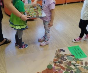 Wychowawczyni częstuje dzieci ciasteczkami w kształcie drzewek