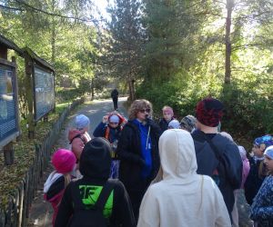 Uczniowie z przewodniczką w parku dinozaurów