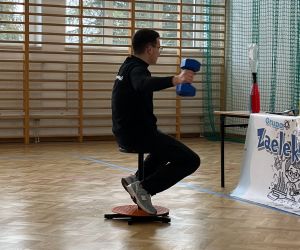 Prowadzący wykonuje doświadczenie z ciężarkiem