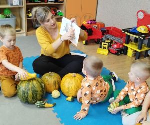 Przedszkolaki z wychowawczynią oglądają różnego rodzaju dynie