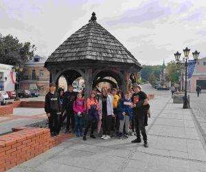 Grupa uczniów przy studni miejskiej na deptaku w Chełmie