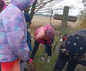 Uczniowie zapalają znicze