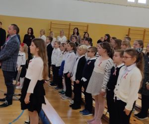 Uczniowie, nauczyciele, zaproszeni goście podczas śpiewania Hymnu Narodowego
