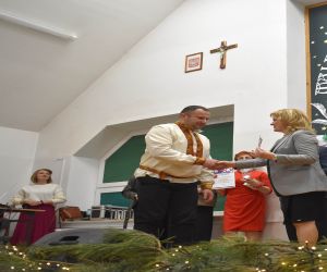 Grupa osób na scenie wewnątrz budynku. Odbiór statuetek, laureaci Konkursu.