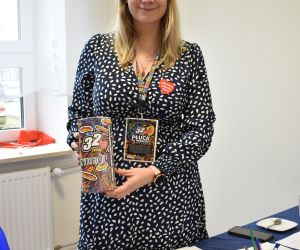 Kobieta wewnątrz budynku, wolontariusz WOŚP.