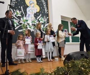 Grupa osób na scenie wewnątrz budynku. Odbiór statuetek, laureaci Konkursu.